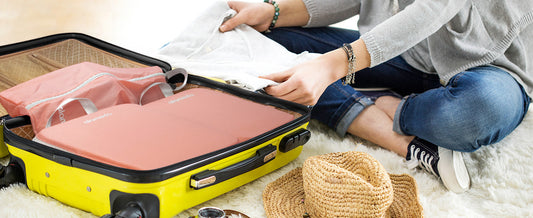 a woman is packing a suitcase with alameda compression packing cubes